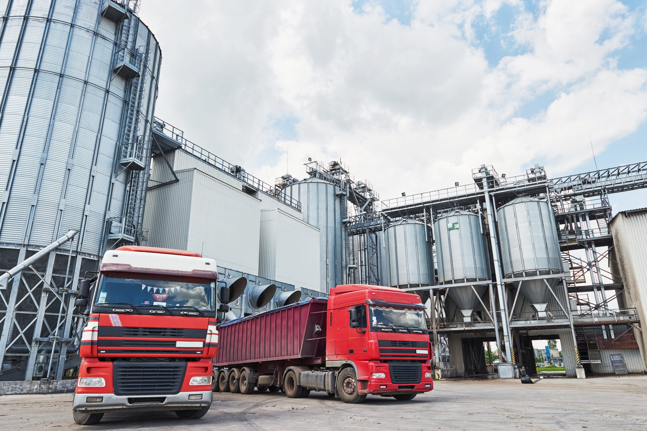 Agricultural Silo - Building Exterior, Storage and drying of grains, wheat, corn, soy, sunflower and two trucks waiting